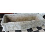 A rectangular reconstituted stone garden trough, cast with scrolls and flowers,