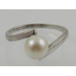 An 18th carat white gold and pearl cross over ring.