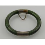 A jade and white metal bangle.