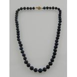 An unusual Tahitian black pearl necklace, with yellow metal clasp.