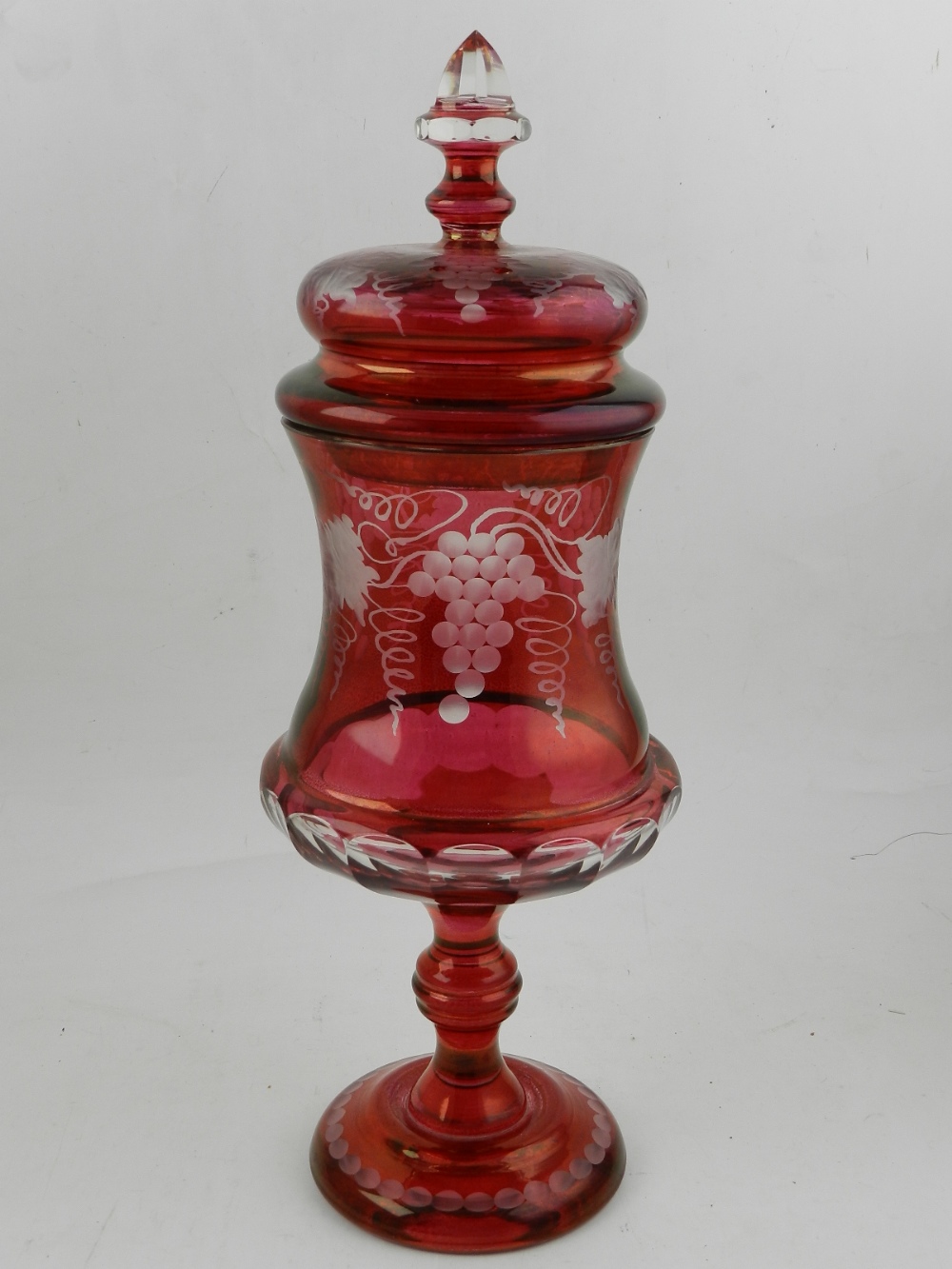 A cranberry glass comport and cover, edged with grapes and vines. H.38cm