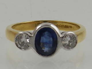 An 18ct yellow gold three stone sapphire and diamond ring, hallmarked Sheffield.