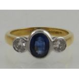 An 18ct yellow gold three stone sapphire and diamond ring, hallmarked Sheffield.