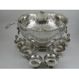 In the 19th century style, a silver plated punch bowl, embossed with flowers and foliage above