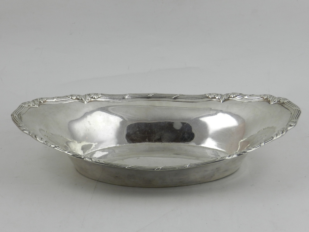 A Continental white metal oval bread dish, possibly Russian, the edges decorated with foliage. W.