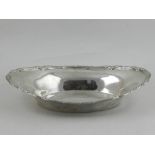 A Continental white metal oval bread dish, possibly Russian, the edges decorated with foliage. W.