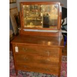 An Edwardian oak dressing chest, with a rectangular raised mirror back above an arrangement of three