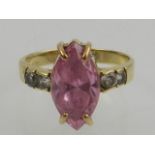 A 9 carat yellow gold, pink and white topaz ring, set with central marquise cut pink topaz, the