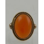 A 9 carat yellow gold and oval cabouchon carnelian set ring.