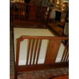 An early 20th century mahogany bedstead, satinwood inlaid, having square legs, raised on casters,