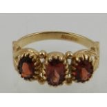 A 9 carat yellow gold three stone garnet ring