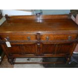 An early 20th century oak sideboard, having two drawers above two cupboard doors, joined by