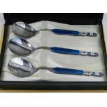 A cased set of three Mitsui stainless steel and enamelled teaspoons.