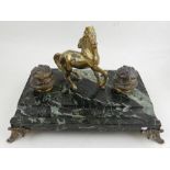 A marble desk set, having cast metal horse flanked by inkwells, raised on scrolling feet. H.20cm W.