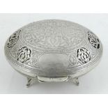 An Egyptian white metal box and cover, having pierced and engraved foliate decoration, raised on