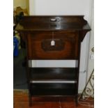 An early 20th century oak bureau, the hinged top revealing a fitted shelved interior, above two open