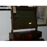 An early 19th century mahogany toilet mirror, the rectangular plate with a shaped and vase