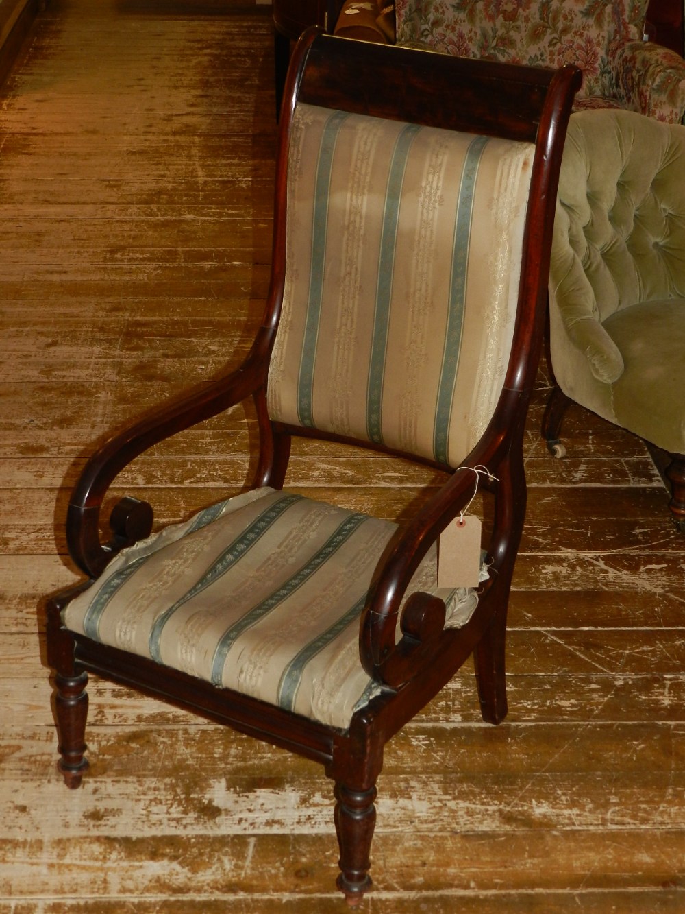 A 19th century mahogany low chair, upholstered in a blue and cream striped fabric, raised on