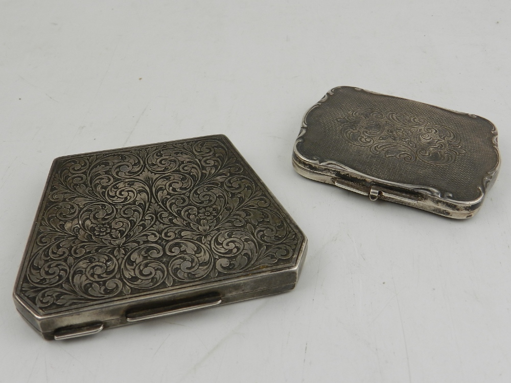 A Continental white metal compact, of rectangular form with scrolling edges, foliate engraved on
