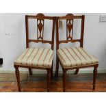 A pair of Edwardian mahogany dining chairs, having a carved and pierced urn design to backrest,