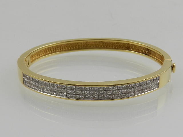 A yellow met and diamond set bangle, stamped 18K, total carat weight 2.5cts.