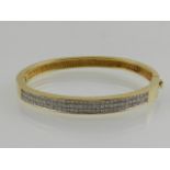 A yellow met and diamond set bangle, stamped 18K, total carat weight 2.5cts.