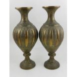 A pair of Middle Eastern cast metal vases, having engraved foliate decoration. H.21cm