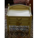 A Contemporary cream painted bedside chest of two drawers, raised on turned supports and stretchers.