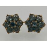 A pair of yellow metal and aquamarine flower shaped earrings, stamped 9ct.