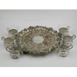 A silver plated tray, decorated with stylised flowers, together with six glasses with silver