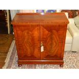 A 20th century mahogany side cabinet, raised on bun feet and square stepped base. H.110cm W.100cm