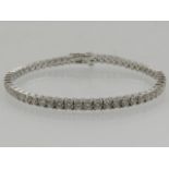 An 18 carat white gold and diamond line bracelet, the round cut stones of approx.