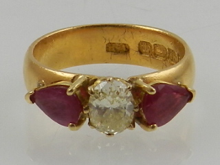 A yellow gold three stone ruby and diamond ring, hallmarked Birmingham.