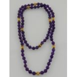 An amethyst and yellow metal beaded necklace.