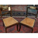 A pair of Regency gilt metal mounted mahogany dining chairs, with cane seats, raised on saber legs.