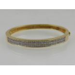A yellow metal and diamond set bangle, stamped 18K, total carat weight 2.5cts.