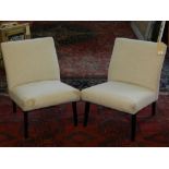 A pair of Contemporary bedroom chairs, upholstered in a stone fabric, raised on ebonised legs.