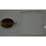A large tigerseye oval stone set in silver on a silver chain