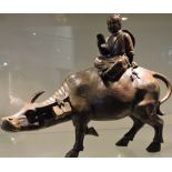 A Chinese bronze of a water buffalo carrying a peasant boy,