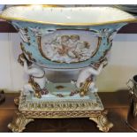 A German style porcelain centre piece, the turquoise bowl supported by two seated putti,