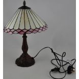A Tiffany-style table lamp with leaded glass shade in ivory and pink. H.