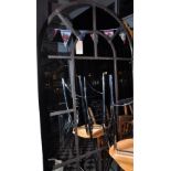 **WITHDRAWN** A large wall mirror with a distressed wrought iron arched window style frame,