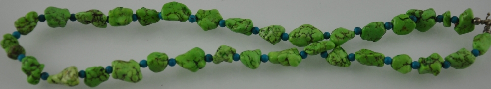A necklace of green turquoise beads alternating with smaller round turquoise beads