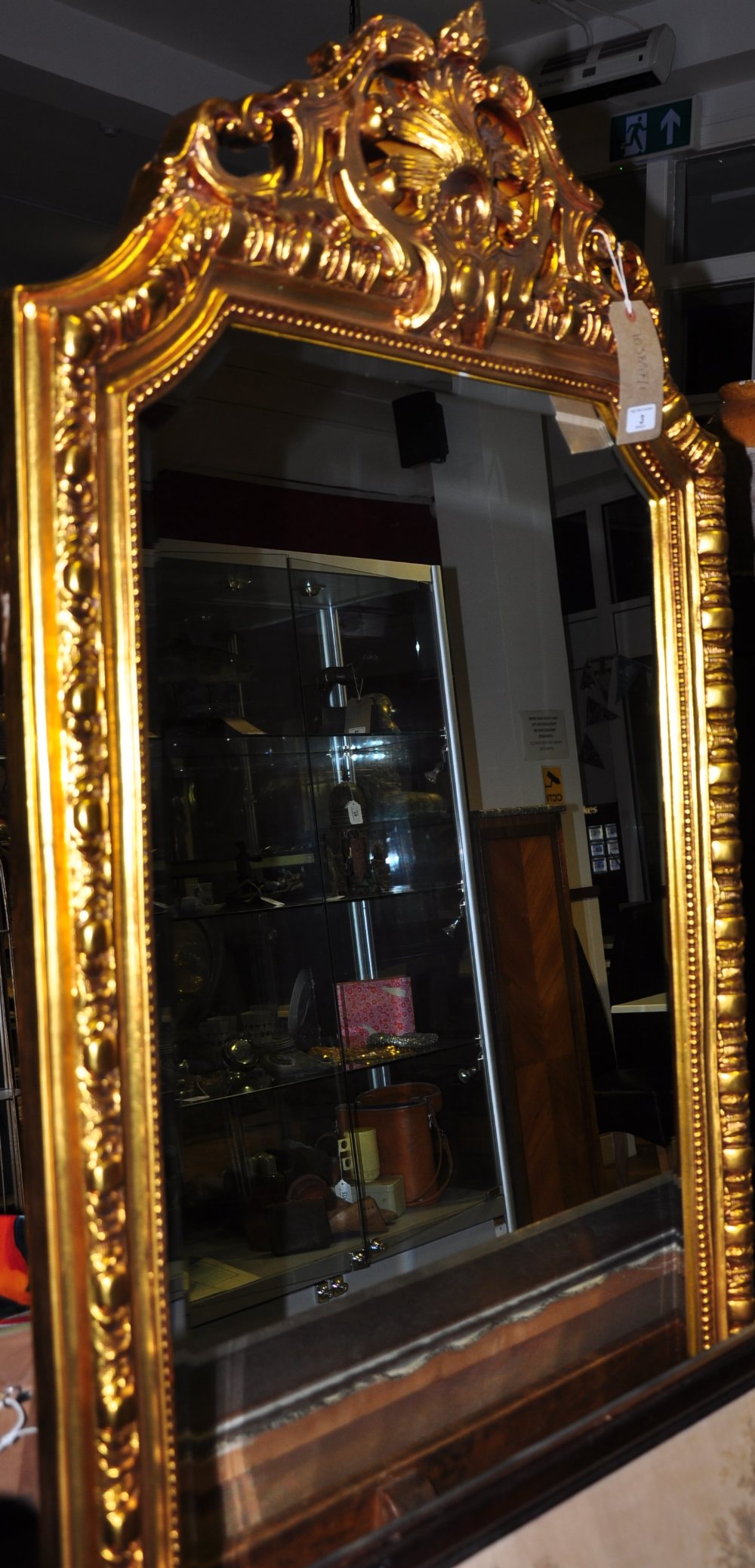 A Louis XVI style gilt egg and dart framed full length mirror with bevelled glass and ornate