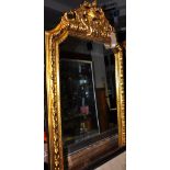 A Louis XVI style gilt egg and dart framed full length mirror with bevelled glass and ornate