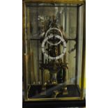 A brass glazed cased skeleton clock with subsidiary seconds dial, together with key,
