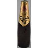 An unopened bottle Carlsberg 68 lager,