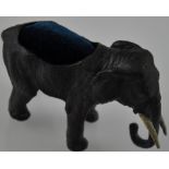 A painted bronze composition elephant pin cushion