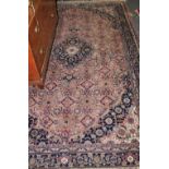 A North West Persian design pink ground carpet woven floral medallions within a triple border,