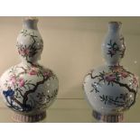 A pair of Chinese porcelain double gourd vases decorated with pomegranate and blossom,